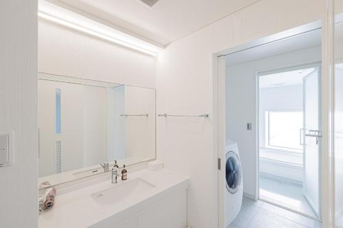 a white bathroom with a sink and a washing machine at MARSOL C,S,Beach hotel - Vacation STAY 51621v in Chigasaki