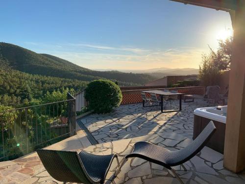 un patio avec deux chaises et une table sur un balcon dans l'établissement Maison dans les hauteurs de valcros, à La Londe-les-Maures