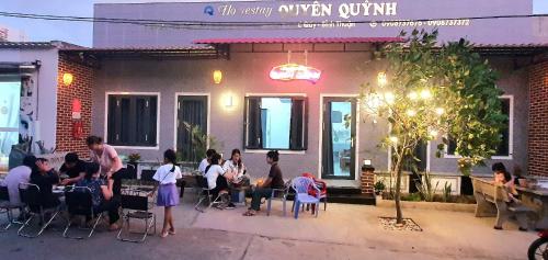 eine Gruppe von Menschen, die vor einem Restaurant sitzen in der Unterkunft Homestay Quyên Quỳnh in Cu Lao Thu
