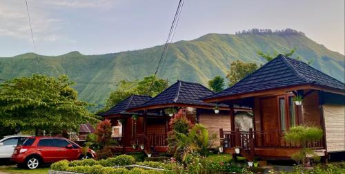 a house with a car parked in front of it at Puncak Rinjani Lodge in Sembalun Lawang