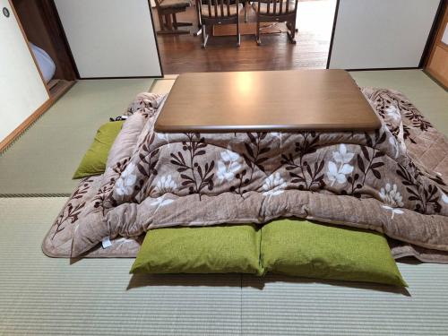 een tafel op een bed met kussens bij 和朗庵 