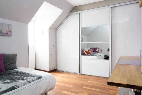 1 dormitorio con paredes blancas y puertas correderas de cristal en EXIGEHOME - Grande maison - 140m² - spacieuse et confortable, en Jouy-en-Josas