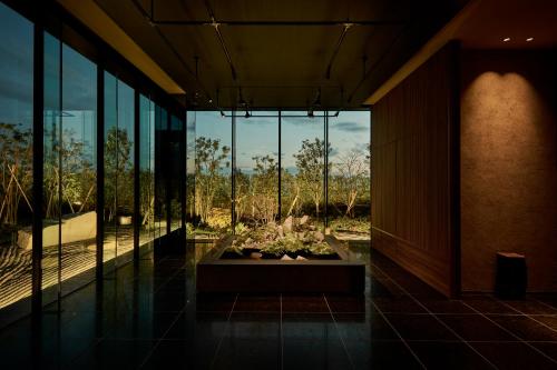 a lobby with a view of a garden through glass at The Royal Park Hotel Iconic Nagoya in Nagoya