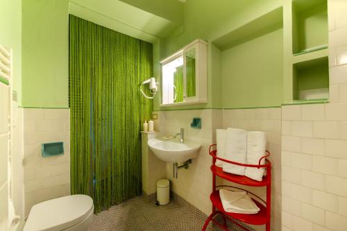 baño verde con aseo y lavamanos en Le Casine - Tintori Apt, en Florencia