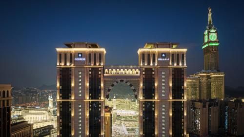 a view of a city at night with a clock tower at Address Jabal Omar Makkah in Makkah