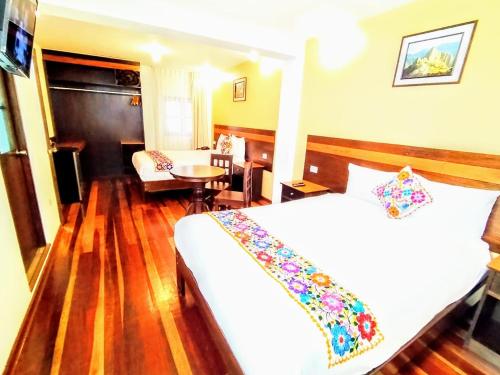a hotel room with a bed and a table at Posada San Blas in Cusco