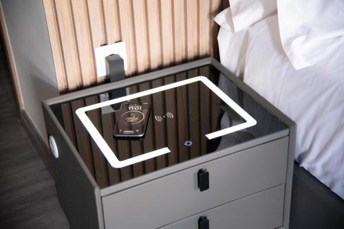 a bed with a night stand with an alarm clock on it at Celia Residence in Athens