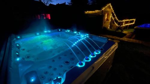 a hot tub with lights in the dark at Spa de campagne Ressource gite THALASSO privatisée INCLUS in Dormelles