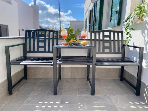 2 stoelen en een tafel op een balkon met drankjes bij Casa Esperanza in Procida