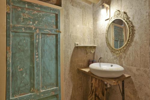 a bathroom with a green door and a sink at Philosophy Hotel in Uchisar