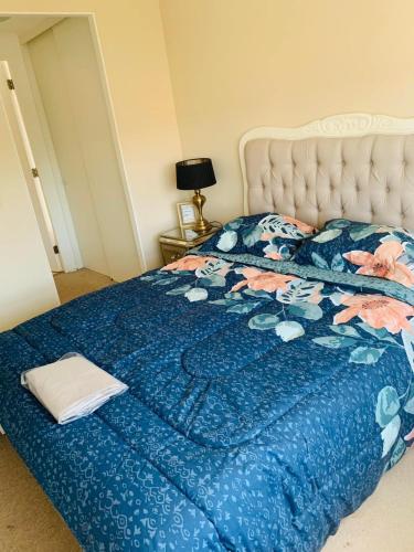 1 dormitorio con 1 cama con edredón azul en Alto mar II, en Viña del Mar
