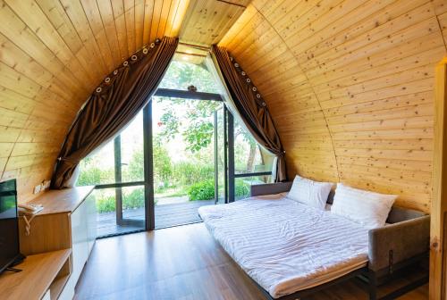 a bed in a room with a large window at KHÁCH SẠN AQUARIUSGARDEN VÂN LONG NINH BÌNH in Ninh Binh