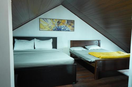 2 camas en una habitación con ático en Lake infinity Penthouse, en Nuwara Eliya