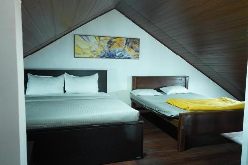two beds in a room with a attic at Lake infinity Penthouse in Nuwara Eliya