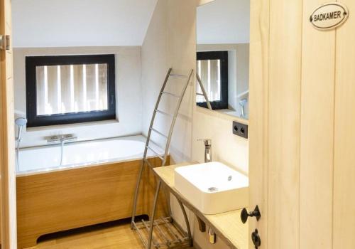 a bathroom with a sink and a bath tub at Huize D'Huys in Riemst