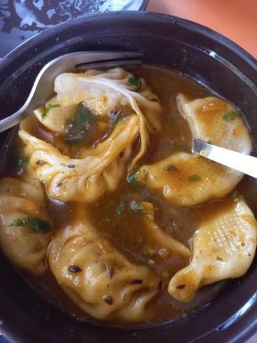 a black bowl of food with noodles and a spoon at Mankamana Resturant and lodge in Butwāl