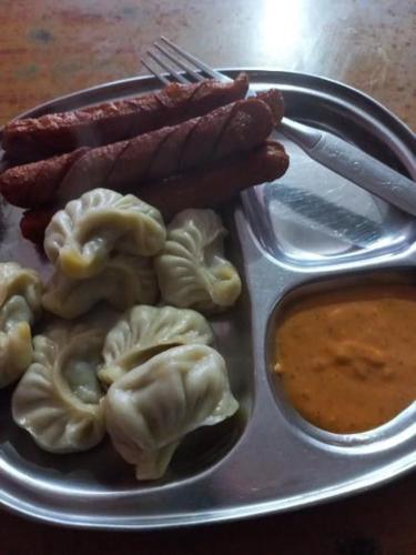 a plate of food with sausage and dumplings and dip at Mankamana Resturant and lodge in Butwāl