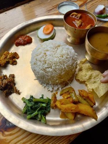 un plato de comida con arroz y verduras en una mesa en Mankamana Resturant and lodge, en Butwāl