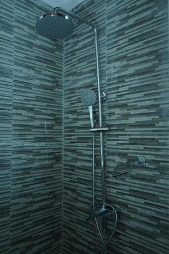um chuveiro na casa de banho com uma parede de tijolos em Lake infinity Penthouse em Nuwara Eliya