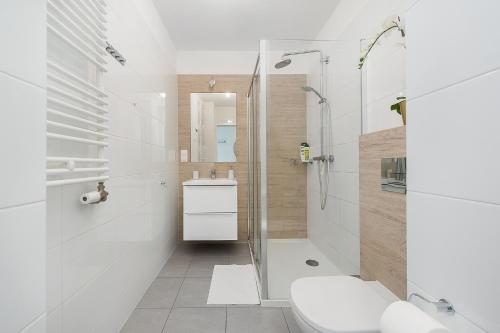 a white bathroom with a shower and a sink at Bella Casa Premium Apartment - 104 Kobierzynska in Krakow