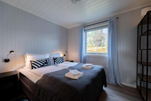 1 dormitorio con 1 cama con 2 toallas en Lofotlove Apartments - Modern and Comfy Apartments Close To Nature, en Sørvågen