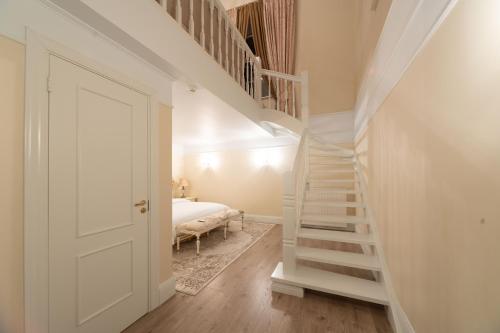 a bedroom with a staircase leading up to a bed at Igates pils in Myza Igate