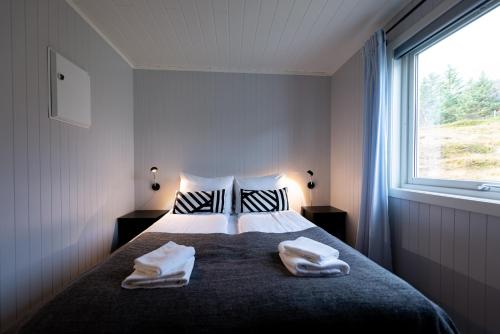 Un dormitorio con una cama con dos toallas encima. en Lofotlove Apartments - Modern and Comfy Apartments Close To Nature, en Sørvågen