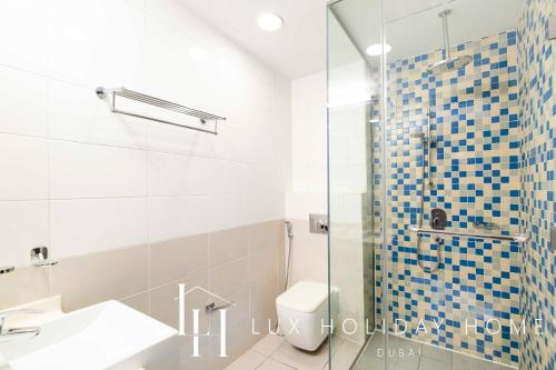 een badkamer met een douche, een wastafel en een toilet bij LUX - Opulent Island Suite Burj Khalifa View 2 in Dubai