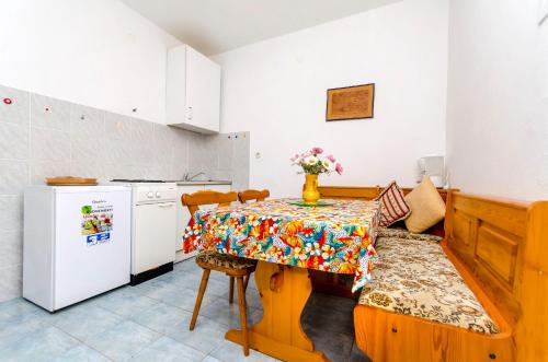 a kitchen with a table with a vase of flowers on it at Apartments Martino in Stomorska