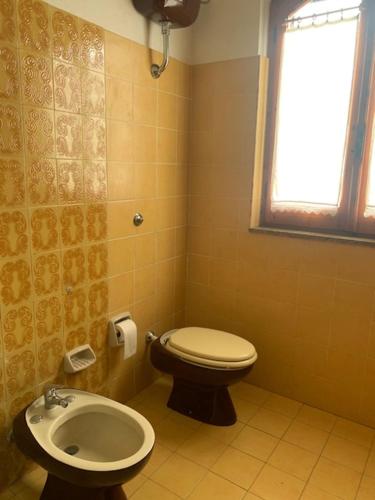 a bathroom with a toilet and a sink at Villa Gioia in Carloforte
