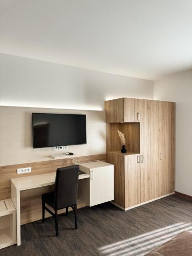a room with a desk with a television and a chair at Hiša Aleš in Kranj