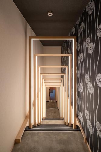 a hallway with white columns and flowers on the wall at UTAKATA HOTEL HIMEJI in Himeji