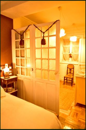 a bedroom with a bed and a door and a chair at Tolosa un mundo de sensaciones in Tolosa