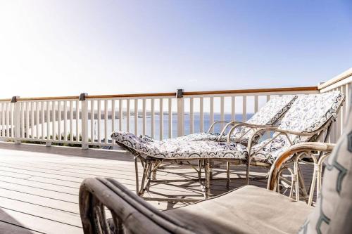 two chairs on a balcony with the ocean in the background at Nautilus ~ Bay of Fires in Binalong Bay