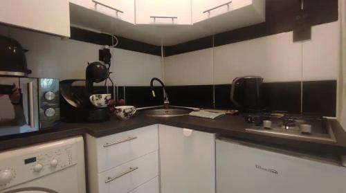 a small kitchen with a sink and a microwave at Bungalow cerca de la playa in Alicante
