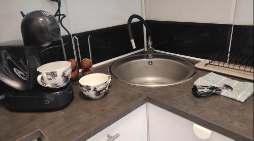 a kitchen counter with two cups and a sink at Bungalow cerca de la playa in Alicante