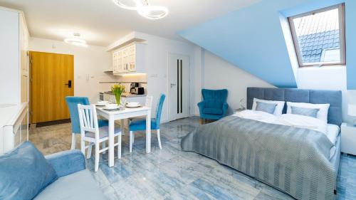 1 dormitorio con 1 cama, mesa y sillas en Apartamenty Sun & Snow Karpacz Nadrzeczna, en Karpacz