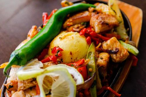 a plate of food with vegetables on a table at Pensiunea Decebal Resort - Cazanele Dunarii in Dubova