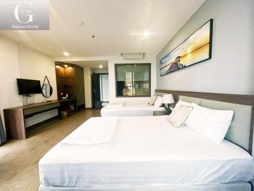 Cette chambre comprend deux lits et une télévision. dans l'établissement 1986's Hotel, à Dong Quan