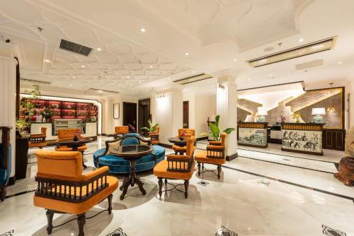 a lobby with chairs and tables in a building at Hanoi Tirant Hotel in Hanoi