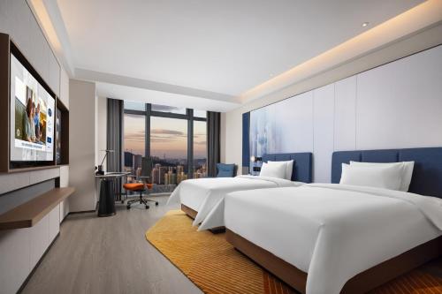 Postel nebo postele na pokoji v ubytování Hampton by Hilton Shenzhen Futian Huaqiangbei