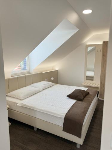 a bedroom with a white bed and a window at Hiša Aleš in Kranj