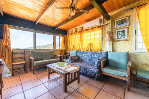 a living room with a couch and chairs and a table at Is Zuddas in Geremèas