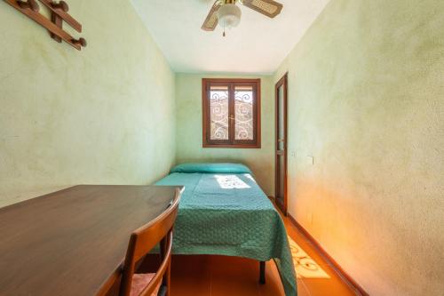 a room with a table and a bed and a window at Is Zuddas in Geremèas