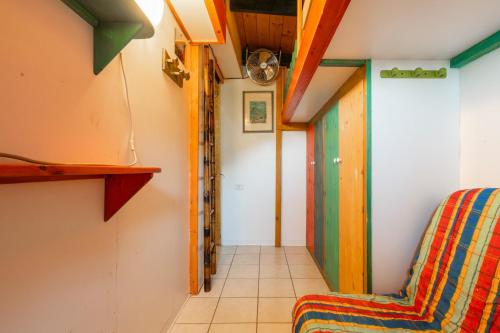 a room with a colorful chair and a hallway at Is Zuddas in Geremèas