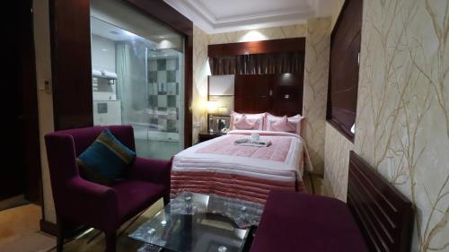 a hotel room with a bed and a chair at SkyCity Hotel Gurgaon in Gurgaon