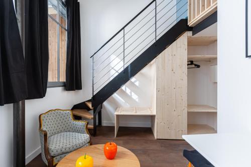 une chambre avec une table et un escalier dans l'établissement Le Baudelaire - Studio en centre ville, à Bordeaux