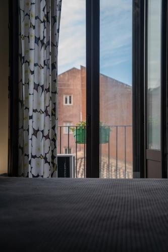 a room with a window with a view of a building at Suite Inn Catania in Catania