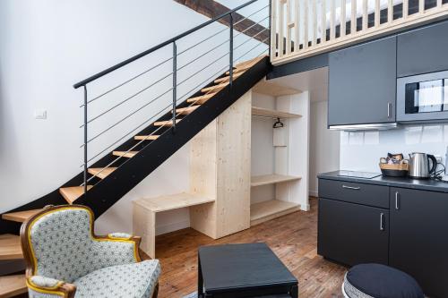 une cuisine avec un escalier dans une mezzanine dans l'établissement Le Victor Hugo - Centre-ville Bordelais, à Bordeaux