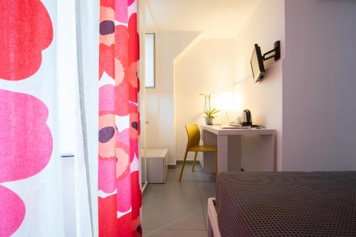 a room with a bed and a desk with a table at Suite Inn Catania in Catania